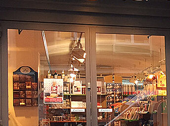 Durch die Glasscheiben der Eingangstür, zur Niederegger Filialie in der Holstenstraße, sind Regale mit Marzipan zu sehen.