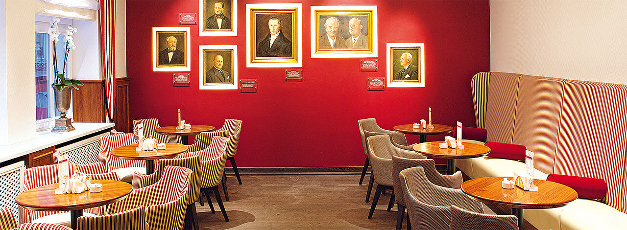 Cafébar im Café Niederegger in Lübeck. Bilder mit den Niederegger Inhabern der vergangenen Generationen hängen an der Wand.